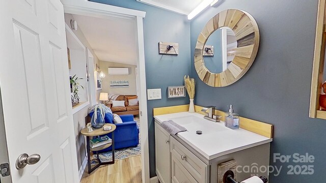 bathroom featuring vanity, a wall unit AC, and wood finished floors