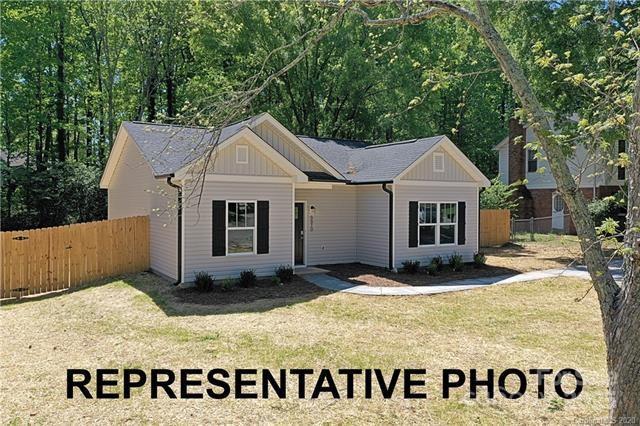 view of front of property featuring board and batten siding, a front lawn, and fence