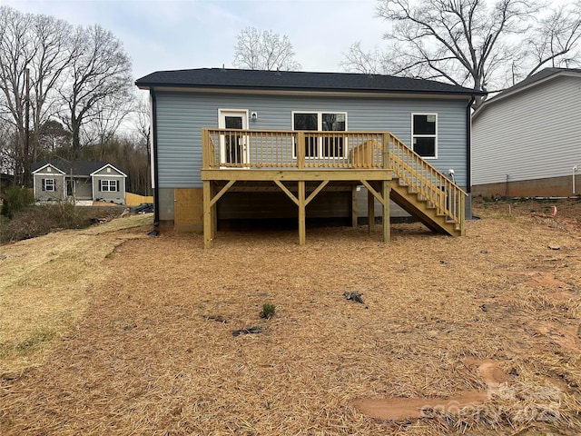 rear view of house featuring a wooden deck and stairs