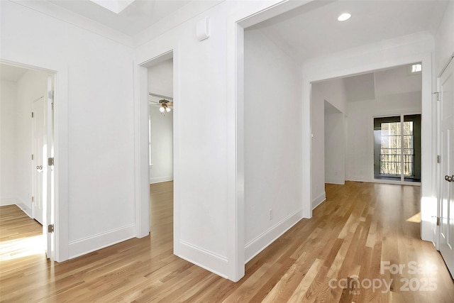 hallway with recessed lighting, light wood-type flooring, and baseboards