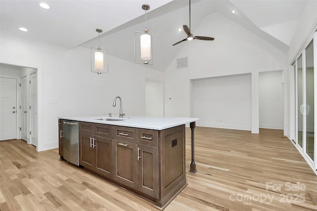 kitchen with visible vents, a sink, light countertops, dark brown cabinets, and dishwasher