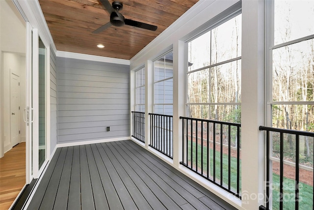 unfurnished sunroom with wood ceiling and ceiling fan