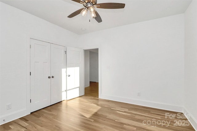 unfurnished bedroom featuring a closet, baseboards, light wood-style flooring, and a ceiling fan