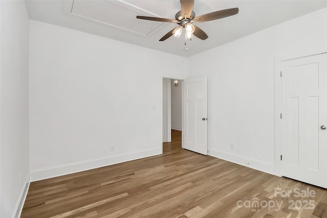 spare room with ceiling fan, baseboards, and light wood-style floors