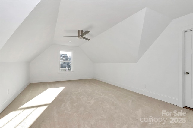 additional living space featuring carpet flooring, a ceiling fan, baseboards, and vaulted ceiling