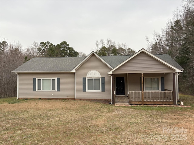 ranch-style house featuring a porch, a front lawn, and roof with shingles