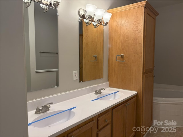 bathroom with double vanity, a bathing tub, an inviting chandelier, and a sink