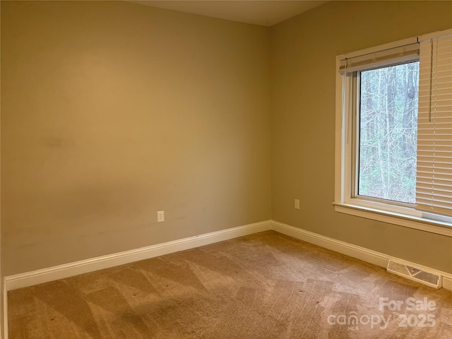 spare room featuring visible vents, carpet floors, and baseboards