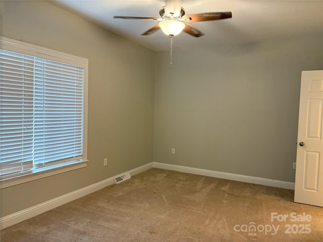 spare room featuring visible vents, baseboards, light colored carpet, and a ceiling fan