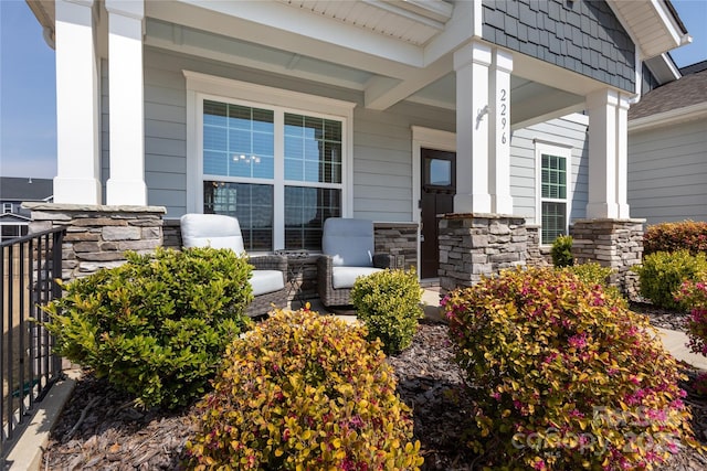 entrance to property featuring stone siding and covered porch