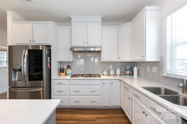 kitchen featuring under cabinet range hood, a sink, white cabinetry, stainless steel appliances, and dark wood-style flooring