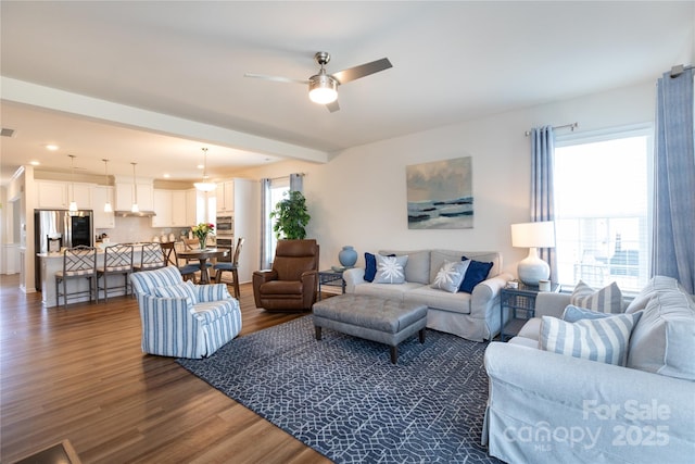 living area with a wealth of natural light, dark wood-style floors, and a ceiling fan