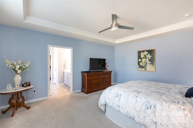 carpeted bedroom with connected bathroom, crown molding, baseboards, a tray ceiling, and a ceiling fan