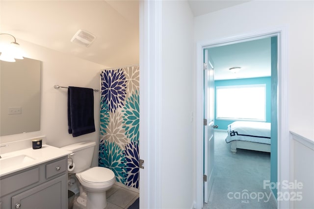 ensuite bathroom with visible vents, toilet, vanity, and connected bathroom