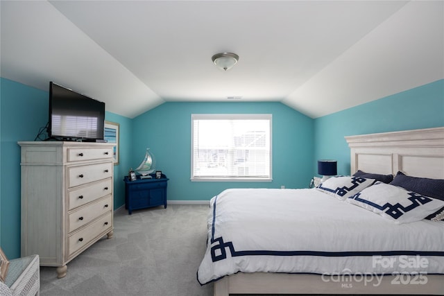 bedroom with light carpet, baseboards, and lofted ceiling