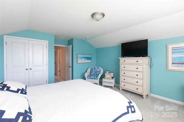 bedroom featuring visible vents, baseboards, lofted ceiling, a closet, and light carpet