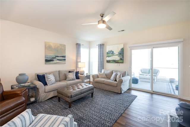 living room featuring ceiling fan, visible vents, and wood finished floors