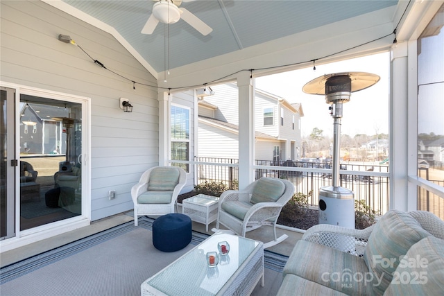 sunroom with a ceiling fan and vaulted ceiling