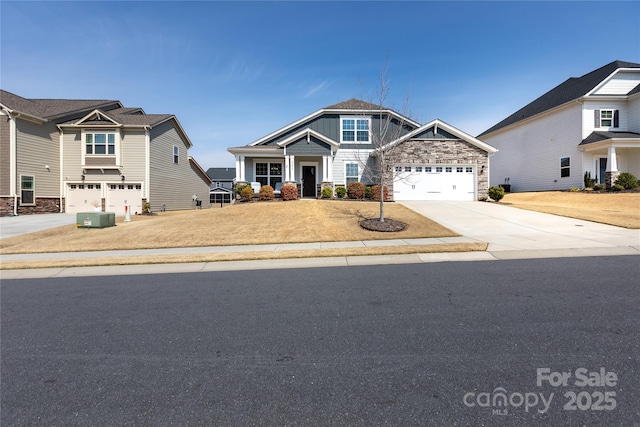 craftsman inspired home with stone siding, driveway, and a garage