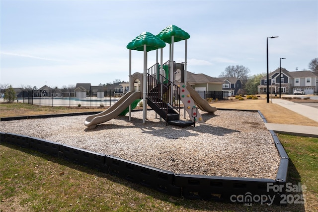 community jungle gym featuring a residential view and fence