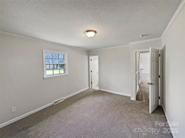 unfurnished bedroom with visible vents, a textured ceiling, carpet floors, crown molding, and baseboards