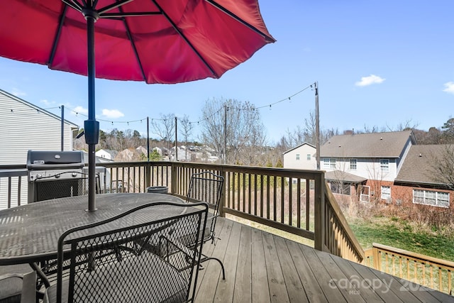 wooden deck with outdoor dining space and grilling area
