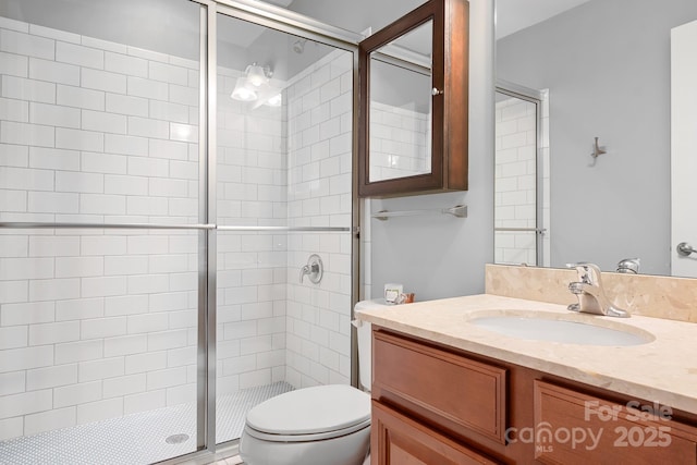 bathroom featuring vanity, toilet, and a shower stall