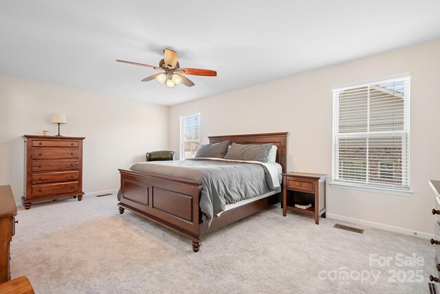 bedroom featuring light carpet, visible vents, multiple windows, and baseboards