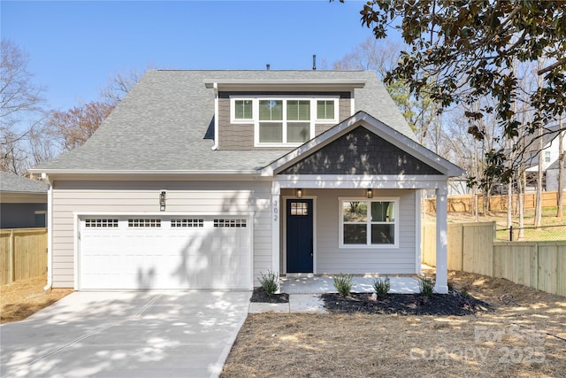 view of front of property featuring roof with shingles, concrete driveway, and fence