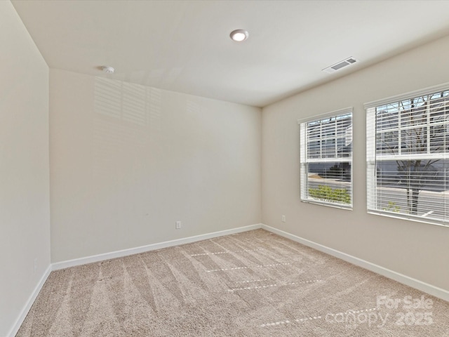 carpeted spare room with baseboards and visible vents