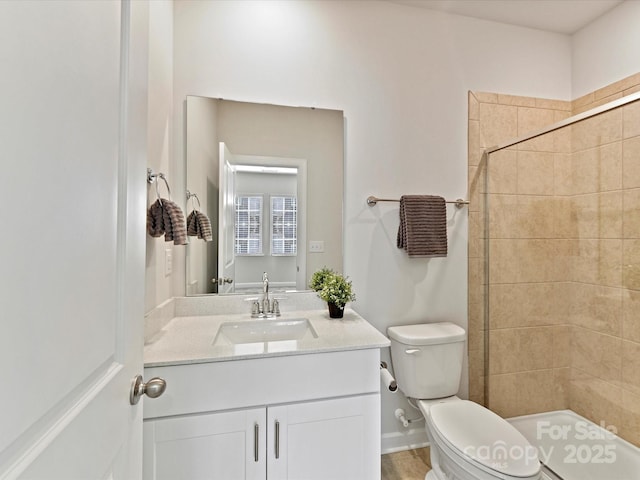 bathroom with toilet, a stall shower, and vanity