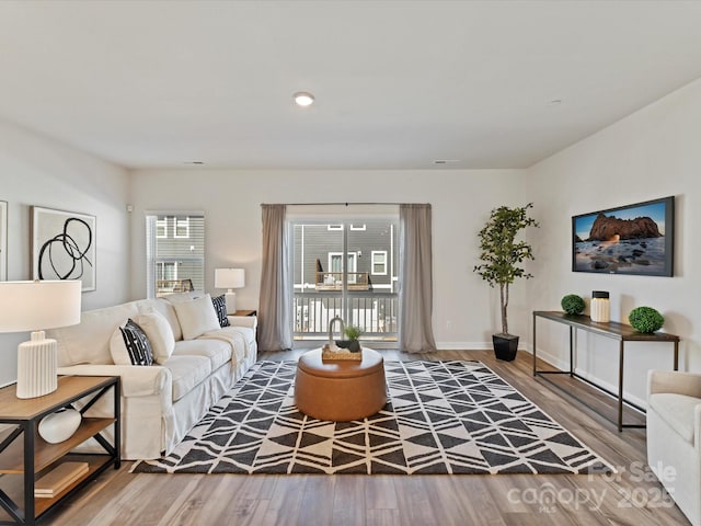 living area featuring visible vents, baseboards, and wood finished floors