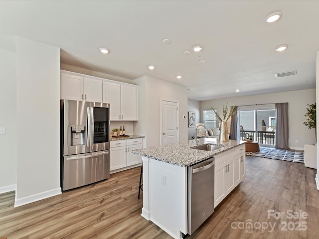 kitchen with a sink, stainless steel appliances, and white cabinets