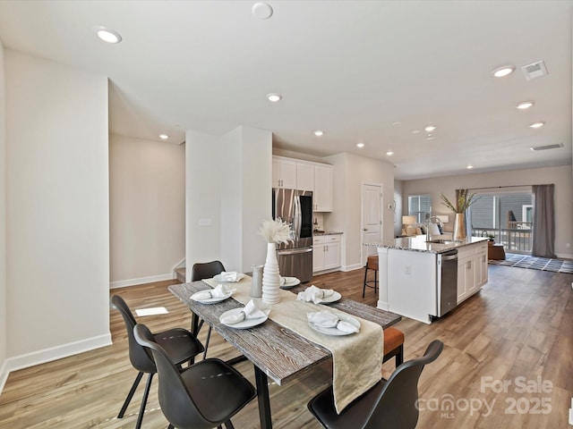 dining room with light wood finished floors, visible vents, recessed lighting, and baseboards