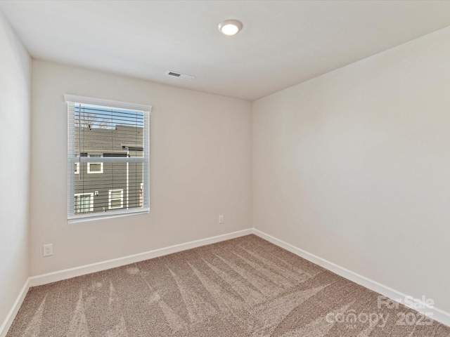 empty room featuring carpet flooring, baseboards, and visible vents