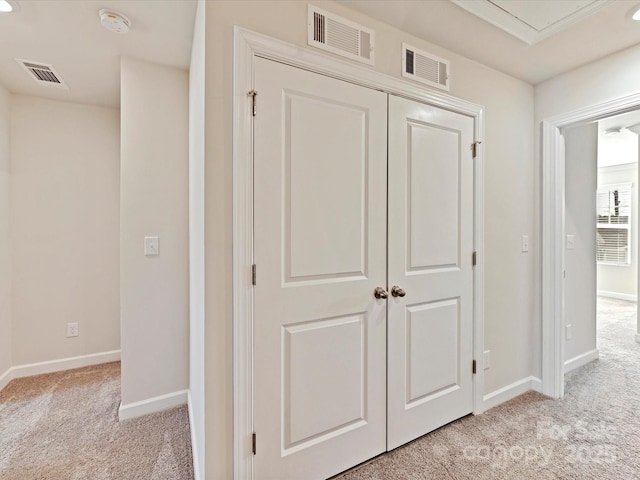 corridor with visible vents, light carpet, and baseboards