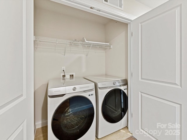 washroom featuring laundry area, visible vents, and separate washer and dryer