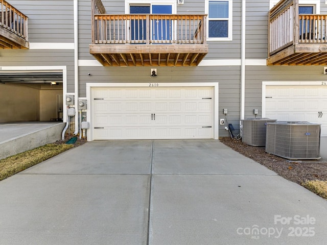 garage featuring central air condition unit and driveway