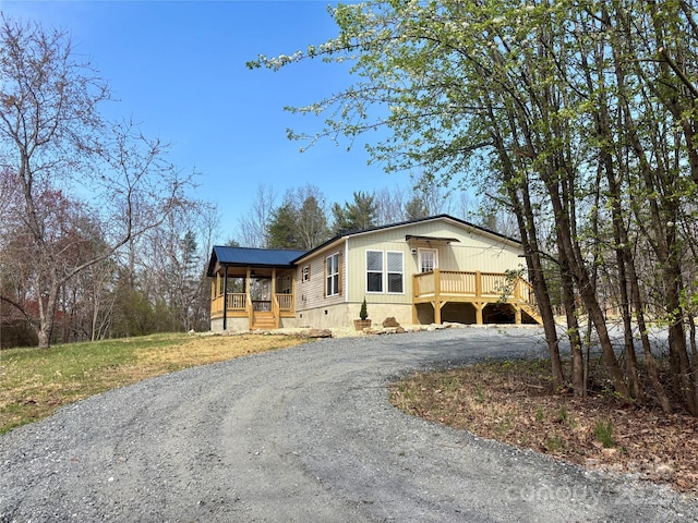 manufactured / mobile home featuring covered porch, driveway, and crawl space