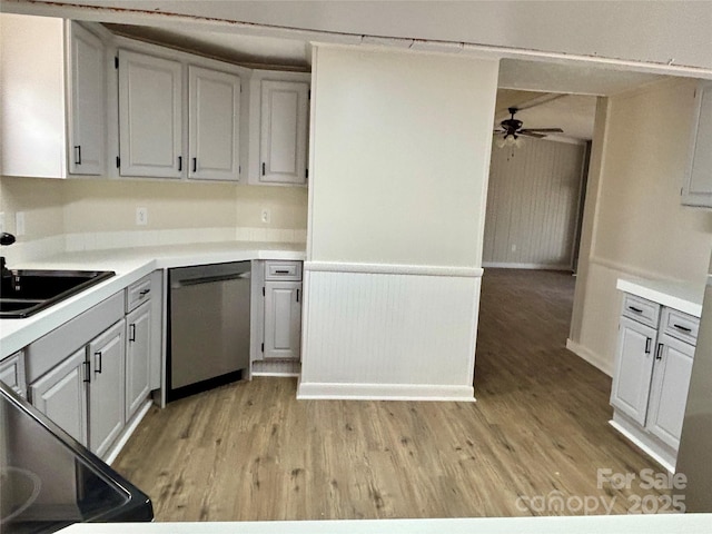 kitchen with ceiling fan, a sink, light countertops, light wood-style floors, and stainless steel dishwasher