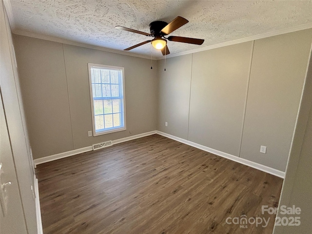 empty room with dark wood finished floors, crown molding, visible vents, and a textured ceiling