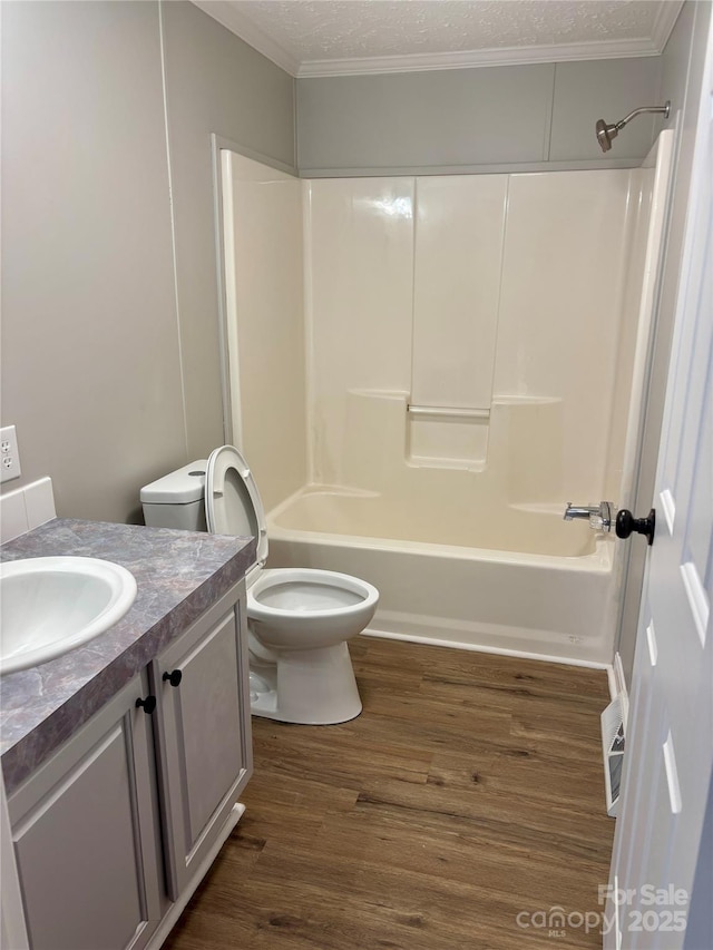 full bathroom with tub / shower combination, toilet, vanity, wood finished floors, and a textured ceiling