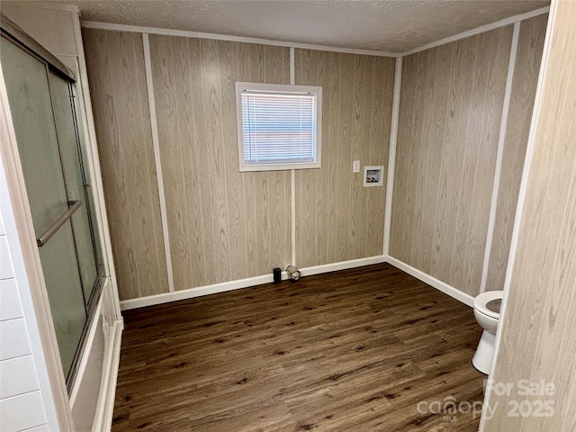 spare room with baseboards and wood finished floors