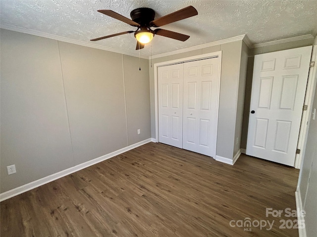 unfurnished bedroom featuring crown molding, ceiling fan, wood finished floors, a closet, and a textured ceiling