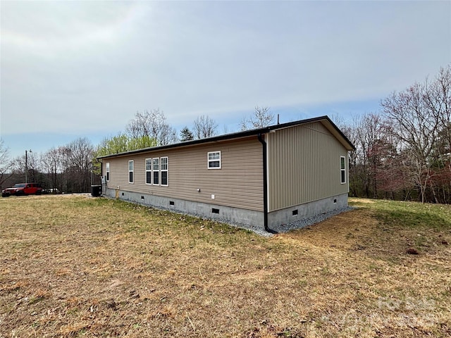 rear view of property featuring crawl space and a lawn