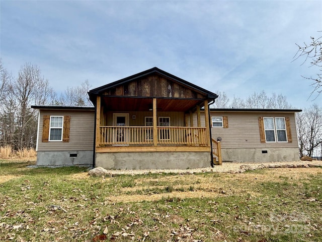 view of front facade with a front yard, covered porch, and crawl space