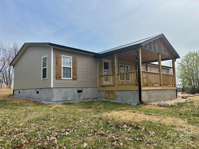 back of property with crawl space, covered porch, and a lawn