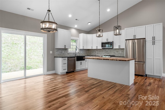 82 Arrowood Rd, Weaverville, NC 28787 - kitchen with appliances with stainless steel finishes, wood counters, a chandelier, tasteful backsplash, and white cabinetry
