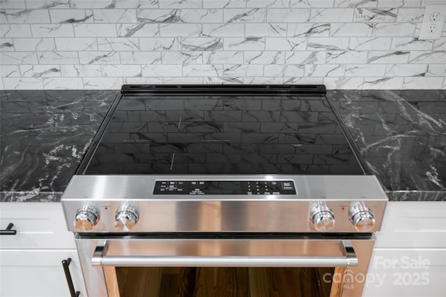 82 Arrowood Rd, Weaverville, NC 28787 - detailed view of electric stove, white cabinetry, and backsplash