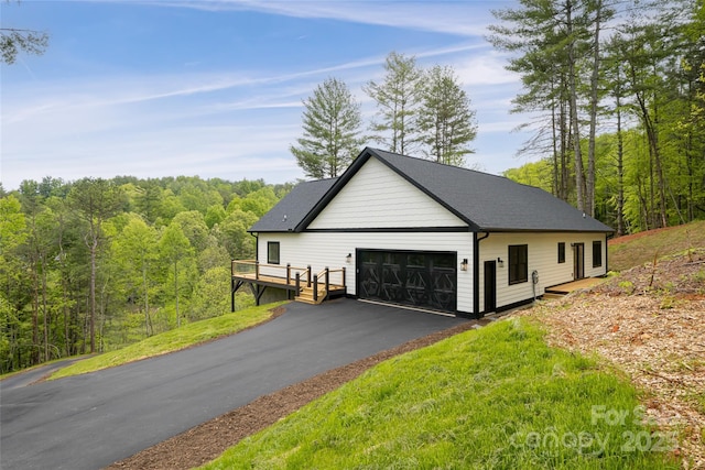 82 Arrowood Rd, Weaverville, NC 28787 - view of side of home with a garage, a wooded view, and a deck